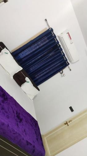 a room with a purple bed and a window at Rest N' Refresh Homes in Visakhapatnam
