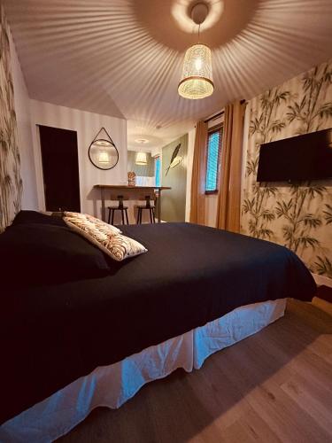 - une chambre avec un lit noir et une table dans l'établissement Chez Jessica, au coeur de Chartres, à Chartres