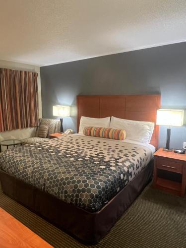 a hotel room with a bed and a couch at Travelers Inn Eugene University in Eugene
