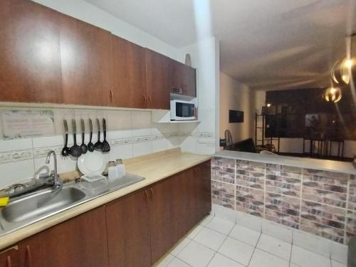 a kitchen with a sink and a microwave at Pacific Spot San Miguel in Lima