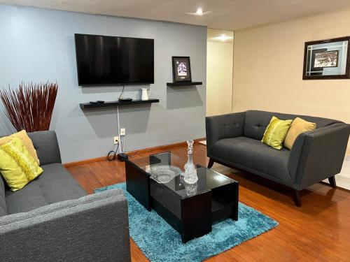 a living room with two couches and a tv at Amplio departamento en la Nápoles, cerca del WTC y Estadio Azul in Mexico City