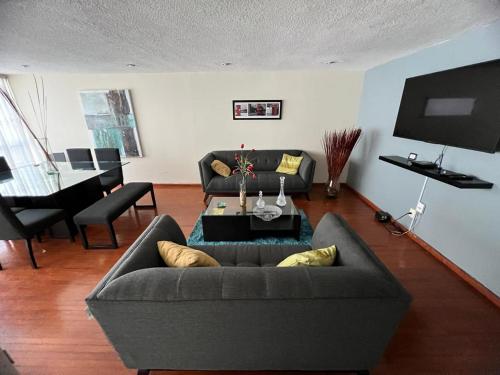 a living room with a couch and a table at Amplio departamento en la Nápoles, cerca del WTC y Estadio Azul in Mexico City