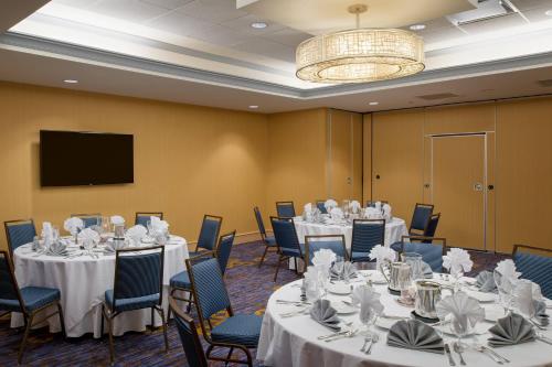 a conference room with tables and chairs and a flat screen tv at Courtyard by Marriott Hanover Lebanon in Lebanon