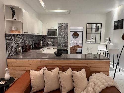 a living room with a couch and a kitchen at Luxurious Apartment in Cape Town