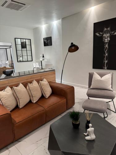 a living room with a brown couch and a chair at Luxurious Apartment in Cape Town
