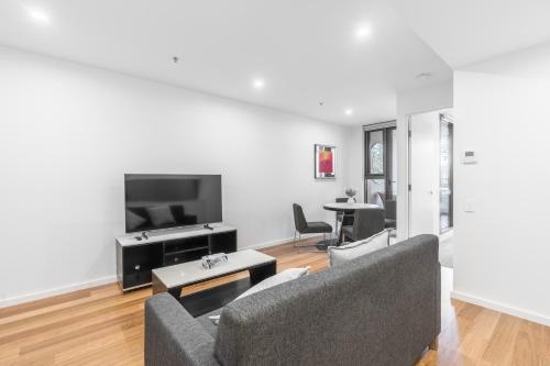 a living room with two couches and a flat screen tv at Modern Apartment next to Canberra Centre in Canberra