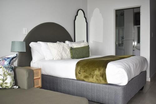 una camera da letto con un letto grande con cuscini bianchi di Zimbali Lakes Boulevard Suites 138 a Ballito