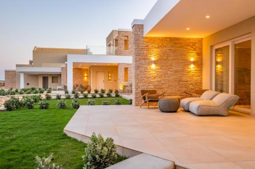 a house with a patio with a lawn at Thalassa Suites in Afiartis