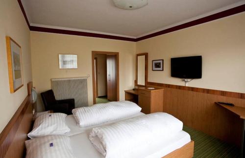 a hotel room with two beds and a flat screen tv at Gasthof Böhm in Persenbeug