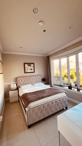 a bedroom with a large bed with a large window at Coze home in Vancouver near YVR in Vancouver