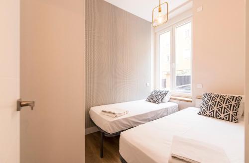 a small room with two beds and a window at Loft chic luminoso in Madrid