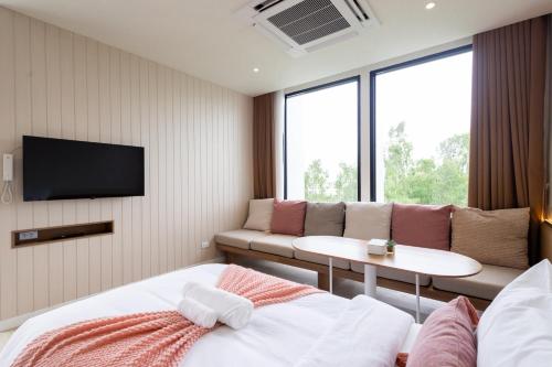 a hotel room with a couch and a table at GOOD Nakhonsawan Hotel in Nakhon Sawan