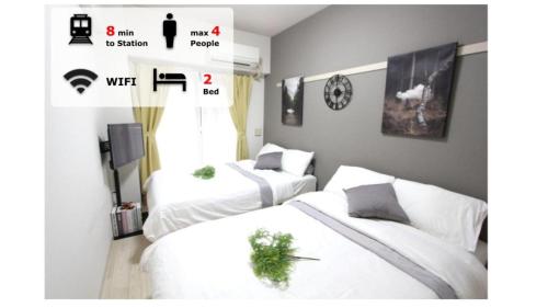 two white beds in a room with a tv at LUANA in KICHIJOJI in Musashino