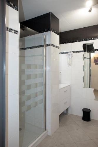 La salle de bains est pourvue d'une douche en verre et de carrelage blanc. dans l'établissement Villa Lympia, à Nice