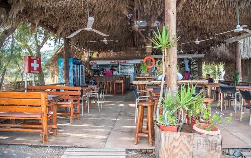 a restaurant with wooden tables and chairs and a bar at Megim Hotel in Palaiochóra