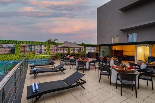 a hotel patio with tables and chairs and a pool at Sterling V Grand Madurai in Madurai