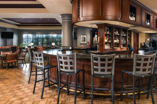 a bar in a restaurant with stools at Renaissance Tulsa Hotel & Convention Center in Tulsa