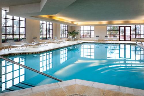 a large swimming pool with tables and chairs at Renaissance Tulsa Hotel & Convention Center in Tulsa