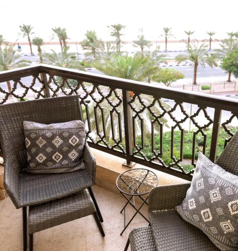 a balcony with chairs and a view of the ocean at Pepkins Holiday Home in Ras al Khaimah