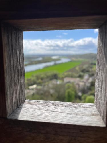 an open window looking out at a green field at Gîte pieds dans l Epte prêt de Giverny in Gasny