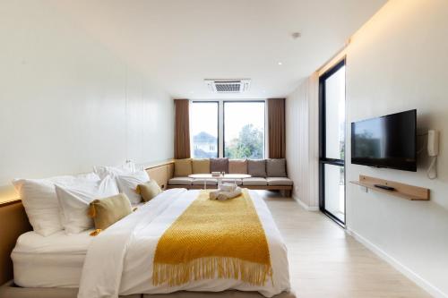 a large bedroom with a large bed and a tv at GOOD Nakhonsawan Hotel in Nakhon Sawan