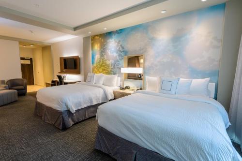 a hotel room with two beds and a painting on the wall at Courtyard by Marriott Lake Jackson in Lake Jackson