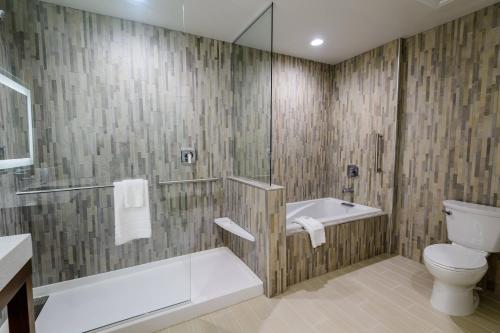 a bathroom with a tub and a toilet and a shower at Courtyard by Marriott Lake Jackson in Lake Jackson