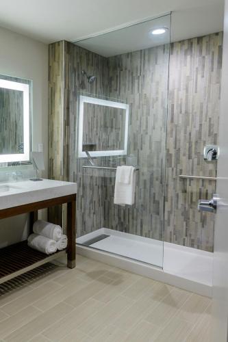a bathroom with a glass shower with a sink at Courtyard by Marriott Lake Jackson in Lake Jackson