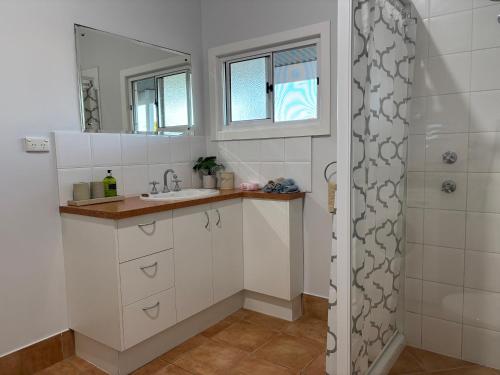 a bathroom with a sink and a shower at Serenity Holiday House Port Lincoln Holiday House in Port Lincoln