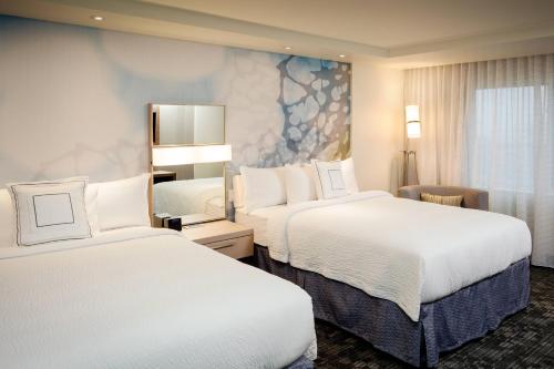a hotel room with two beds and a chair at Courtyard by Marriott Walla Walla in Walla Walla