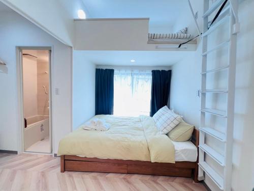 a bedroom with a bed and a window and shelves at Sugamo 1F-TS0334 in Tokyo