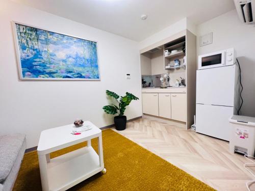 a living room with a white refrigerator and a table at Sugamo 1F-TS0334 in Tokyo