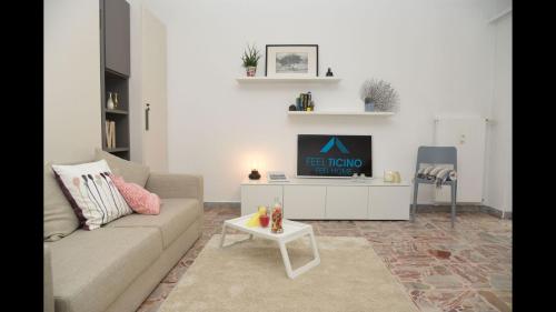 a living room with a couch and a tv at Bright Stunning Central Apartment In Front Of Lugano Lake in Paradiso