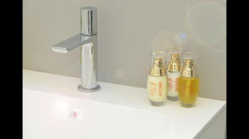 a group of three bottles sitting on top of a sink at Bright Stunning Central Apartment In Front Of Lugano Lake in Paradiso