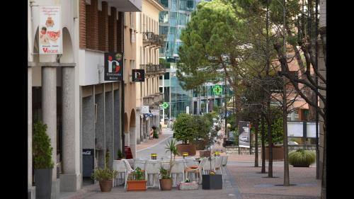 an empty city street with tables and potted plants at Bright Stunning Central Apartment In Front Of Lugano Lake in Paradiso