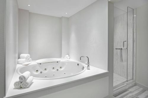 ニスクにあるRenaissance Edmonton Airport Hotelの白いバスルーム(バスタブ、シャワー付)