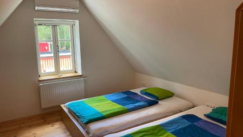 two beds in a room with a window at Cottage Faflik - Air Con And Own Sauna, Swedish house no 001 in Vlkov