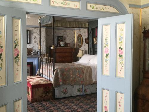 1 dormitorio con cama con dosel y chimenea en St Benedict - Victorian Bed and Breakfast en Hastings