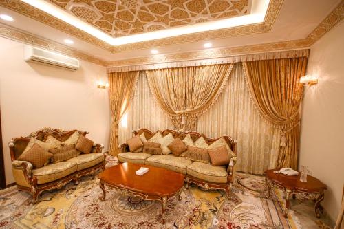 a living room with two couches and a table at Al Bada Hotel and Resort in Al Ain