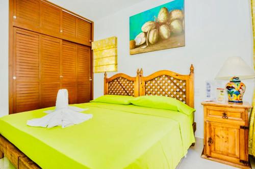 sypialnia z zielonym łóżkiem z drewnianym zagłówkiem w obiekcie Superior Budget Room With Swimming Pool Air Conditioning and Parking w mieście Playa del Carmen