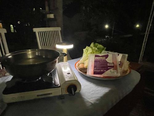 a mortar and pestle next to a bowl and a plate of food at Monsamkien Farmstay in Phayao