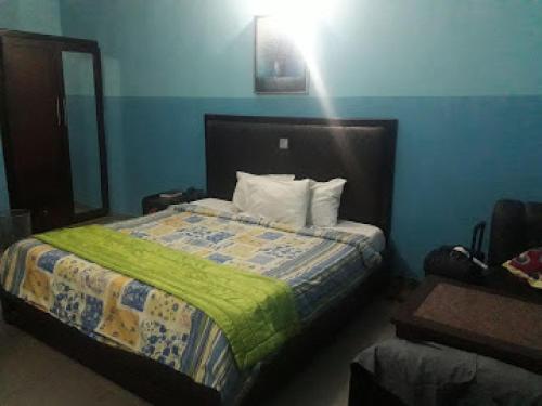 a bedroom with a bed with a green blanket at Grand Serene Hotel - Superior in Ibadan