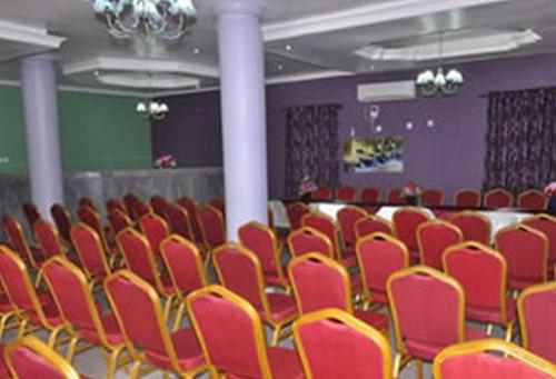 an empty room with red chairs and a table at Sheriffyt Royale Hotel Suites - Deluxe in Ikorodu