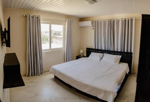 Un dormitorio con una cama blanca con una ventana. en Wonderful 2-bedroom apartment 2 km from Eagle beach, en Palm-Eagle Beach
