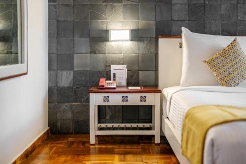 a bedroom with a bed and a nightstand next to a bed at Sterling Kodai Lake in Kodaikānāl