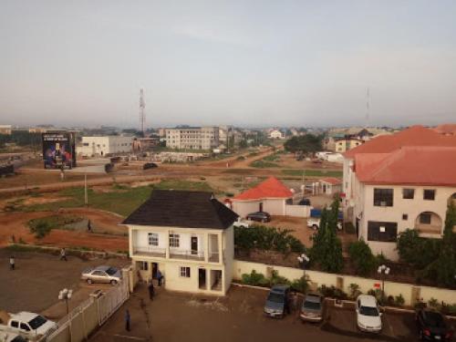 a city with cars parked in a parking lot at Immaculate Royal Int Hotel - Standard in Owerri