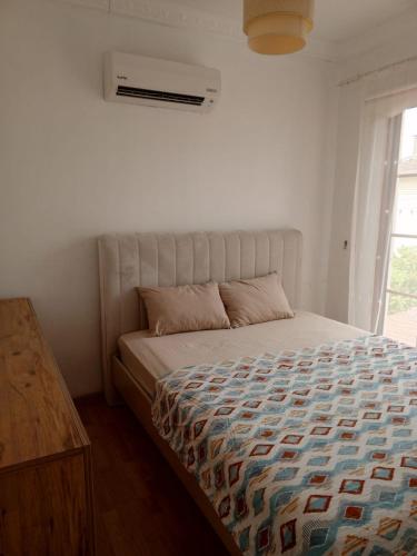 a bed in a white room with a window at Villa Beyazıt in Side