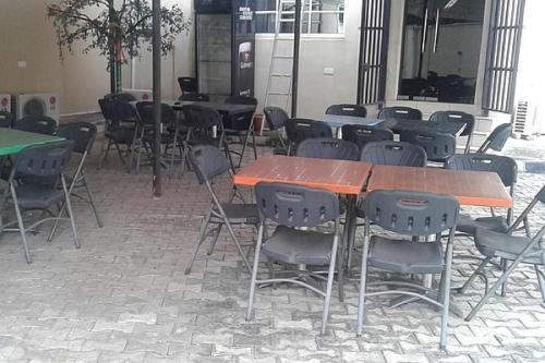 a group of tables and chairs in a room at Orchard Hotel - Standard in Ibadan