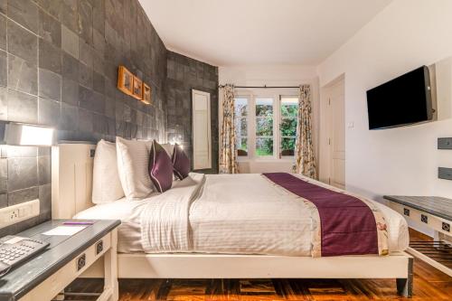 a bedroom with a large bed and a desk at Sterling Kodai Lake in Kodaikānāl