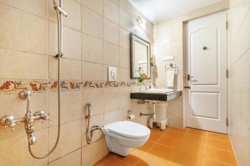 a bathroom with a toilet and a shower and a sink at Sterling Kodai Lake in Kodaikānāl